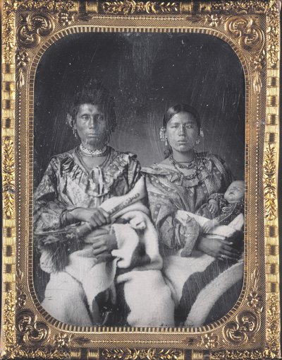 Portret van Mahee (Mes) met zijn vrouw Kunzanya en kind van de Iowa. Ze dragen kralen sieraden en dikke dekens. Mahee houdt een voorwerp in zijn hand door Thomas M. Easterly